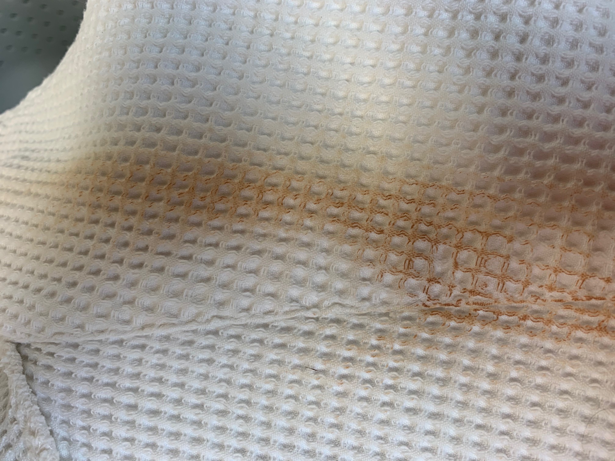 Close up of white robe with big brown makeup stain