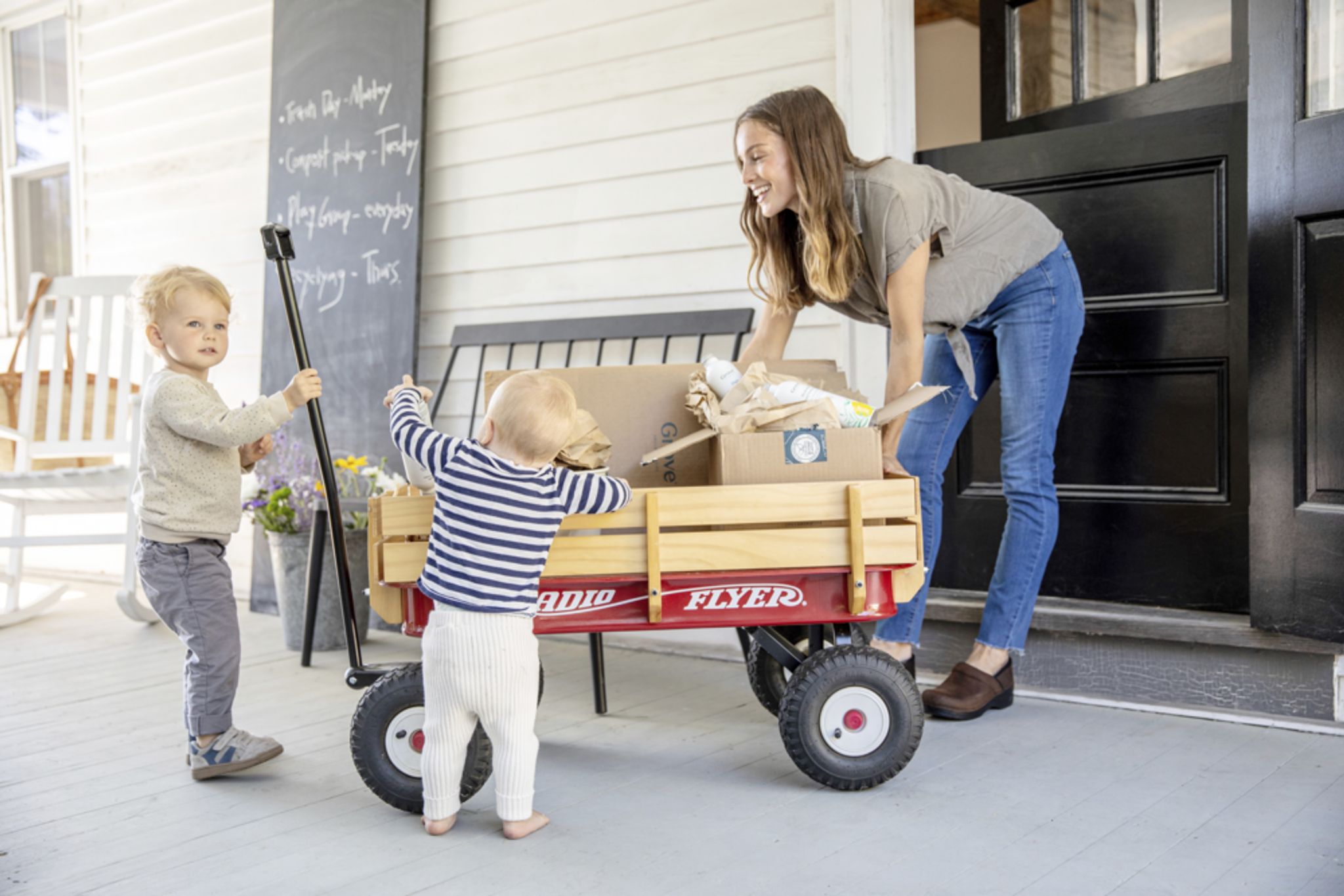 Photo of woman and two children with a wagon full of cardboard
