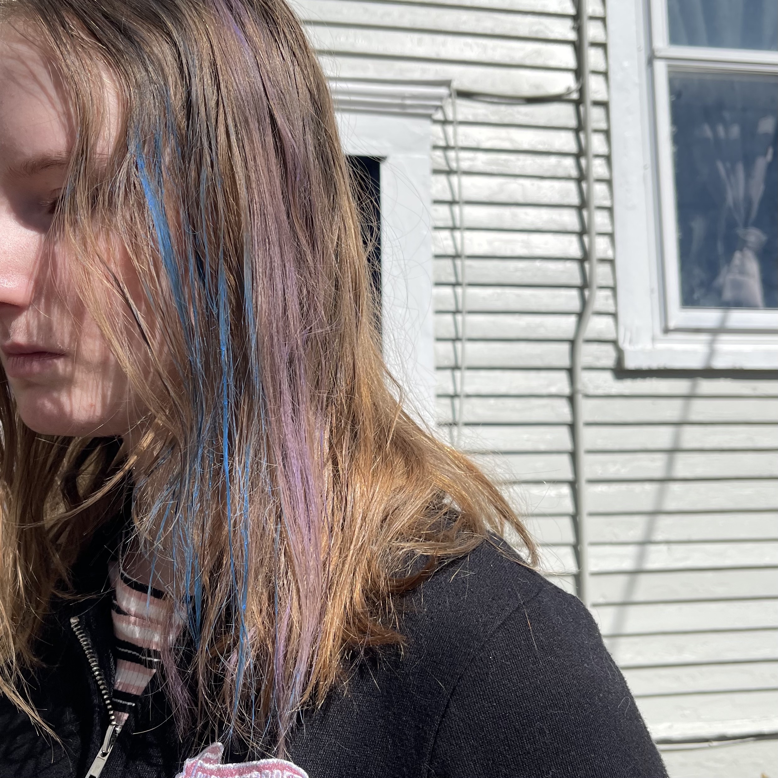 a child with blue and pink hair chalk in her blonde hair