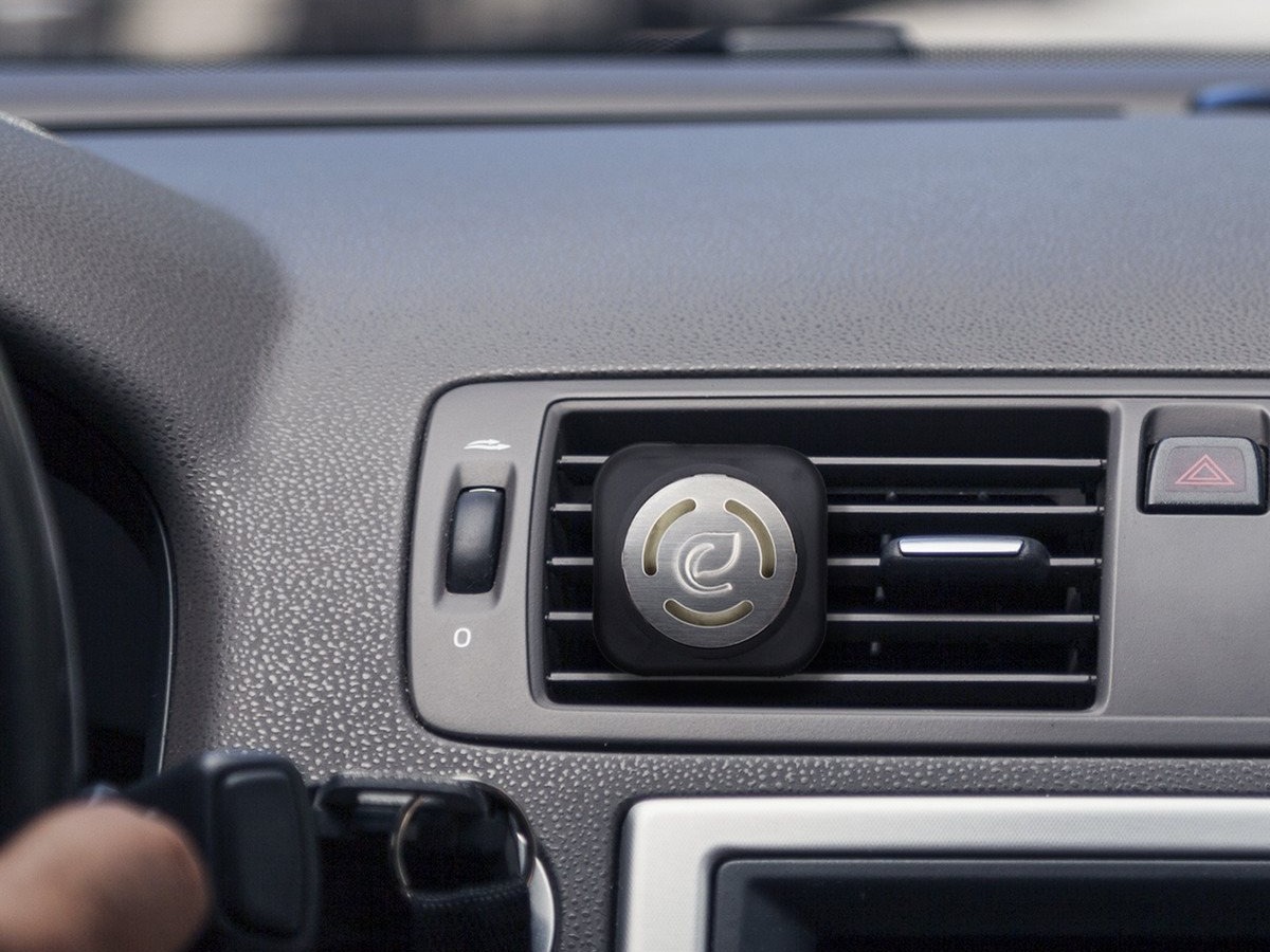 Image of black car dash and vent with air plug in