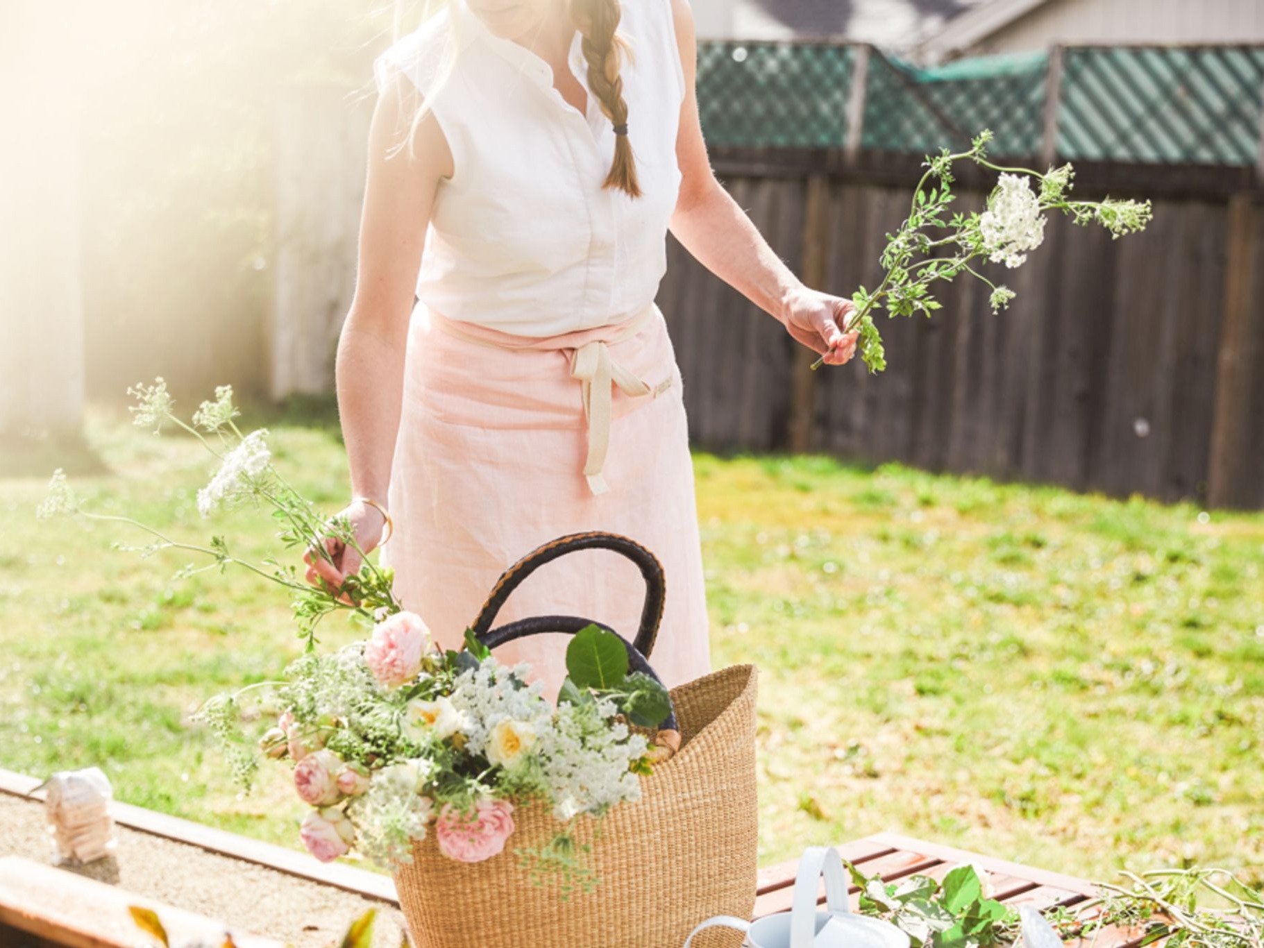 Photo of woman in yard putting flowers in basket
