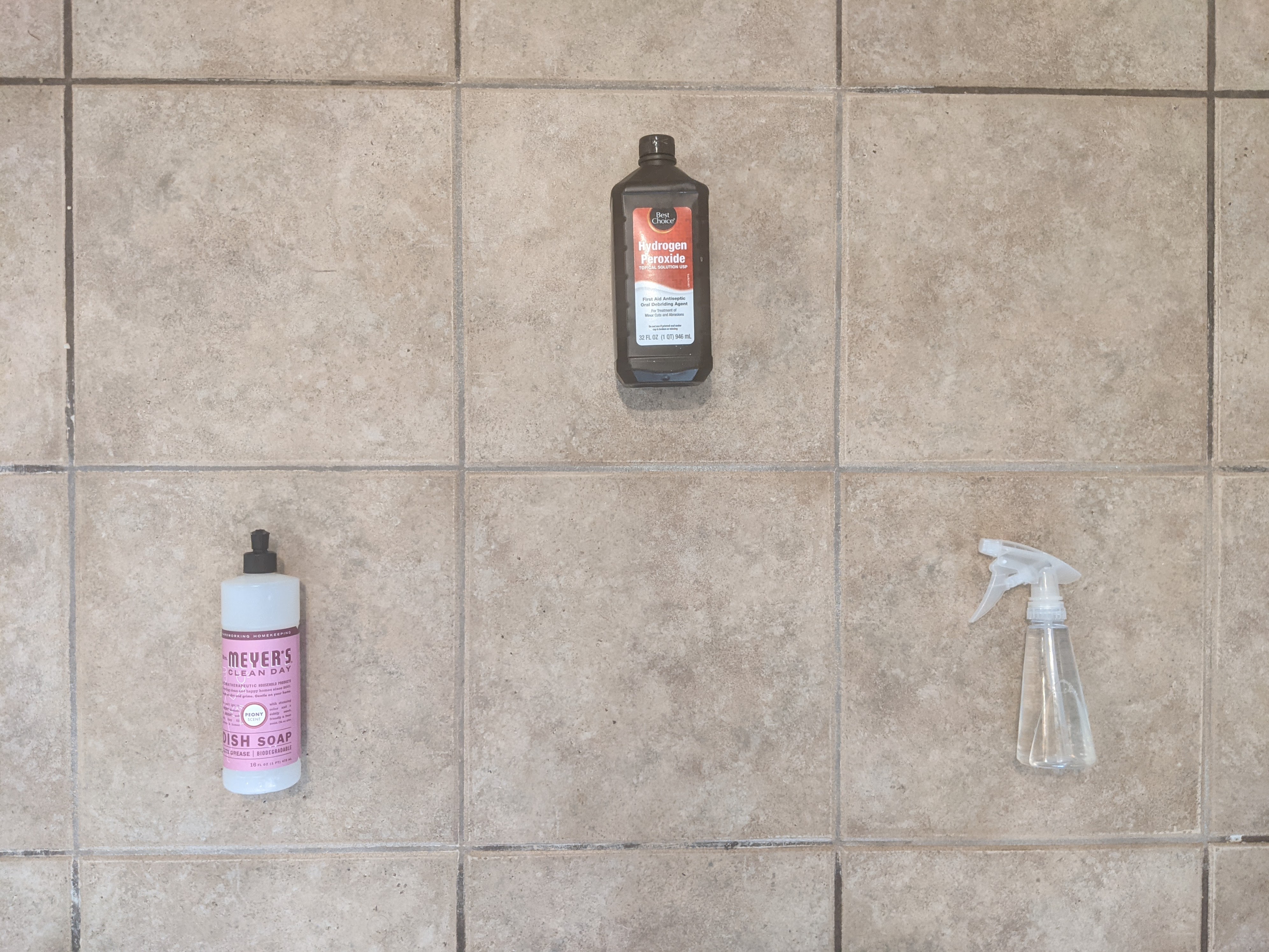 Photo of three different cleaners placed in three different tiles that have been cleaned