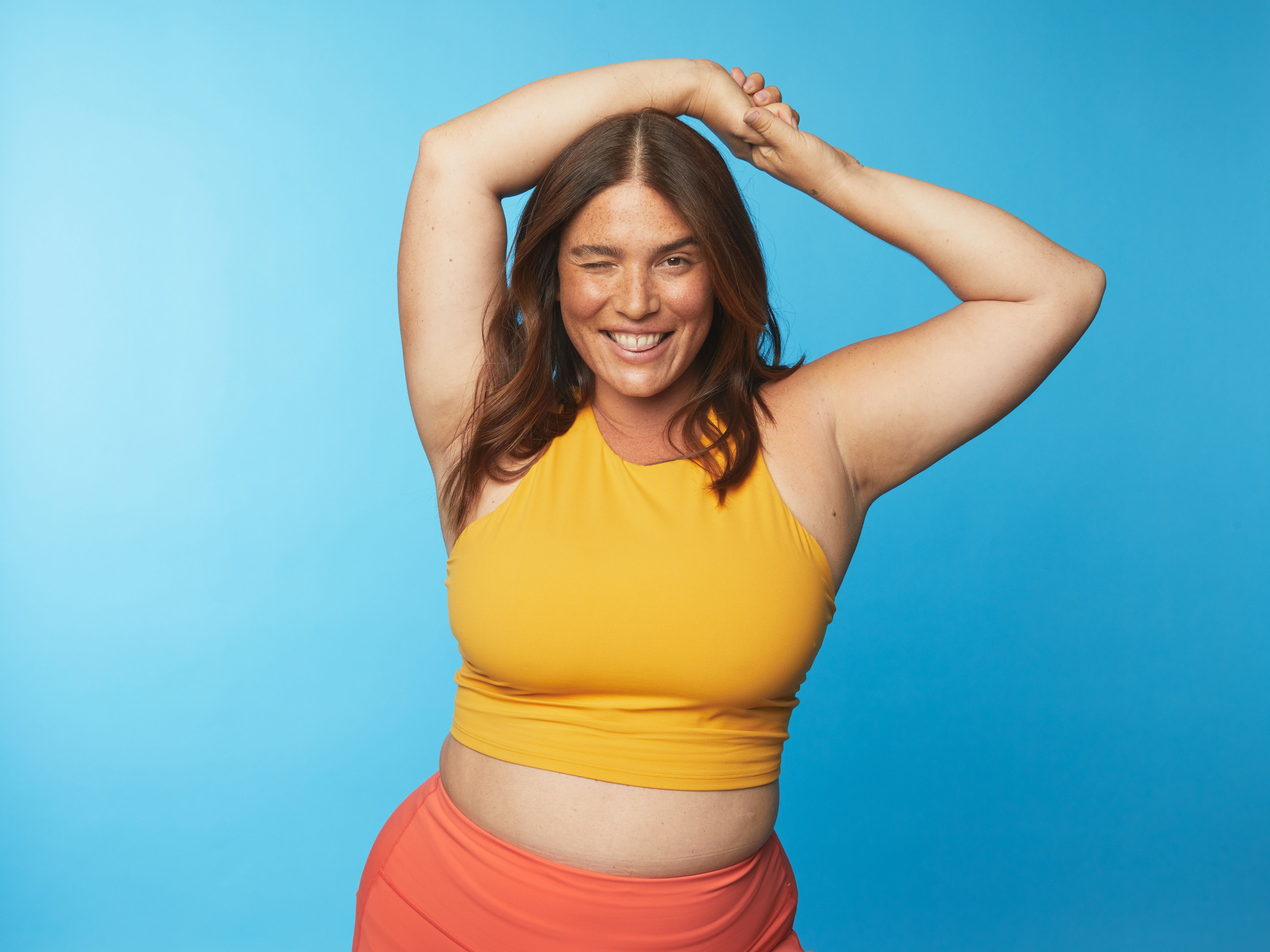 Photo of woman in crop top and leggings winking