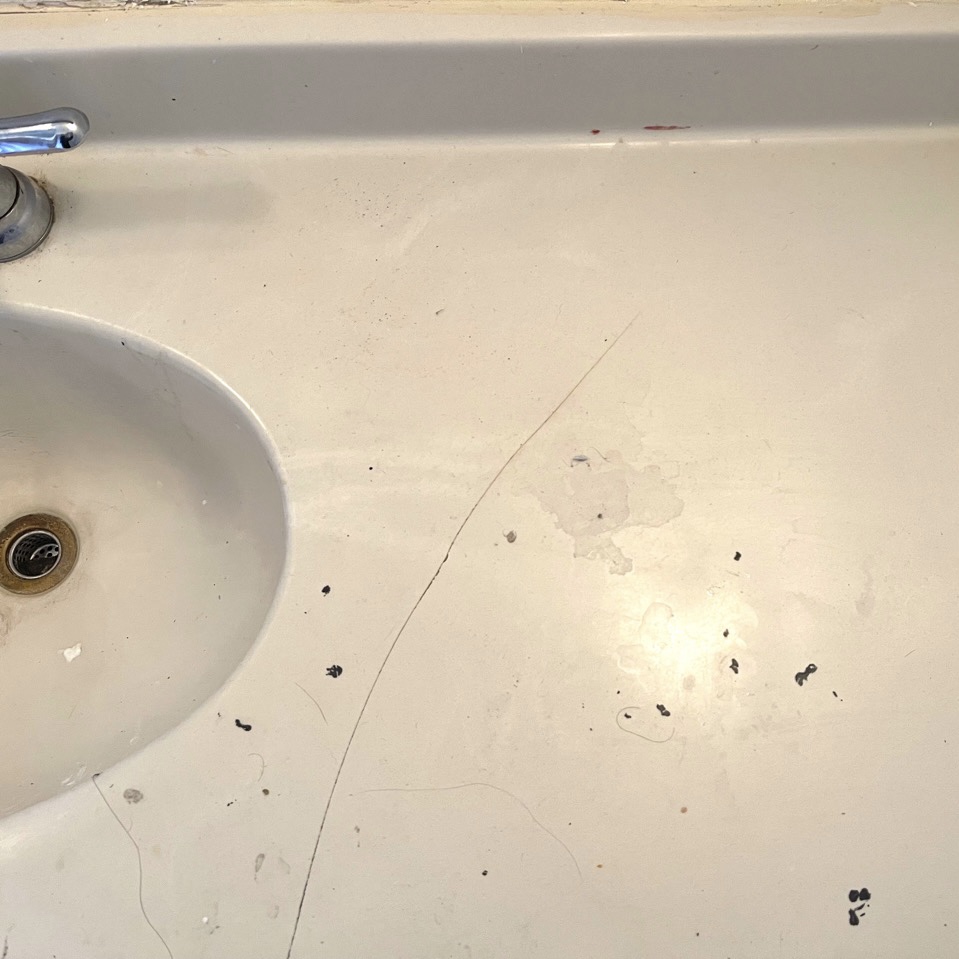Dirty bathroom counter next to sink