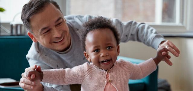 Dad helping toddler walk