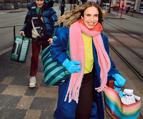 People rushing to a transit stop with luggage and bags, on their way to continue their journey by public transport.