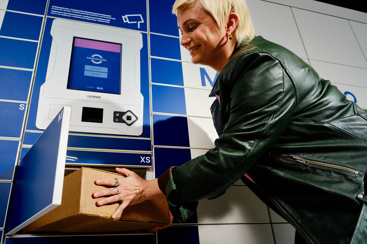 En kund placerar ett paket i Matkahuoltos paketautomat.