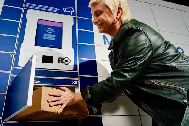 En kund placerar ett paket i Matkahuoltos paketautomat.