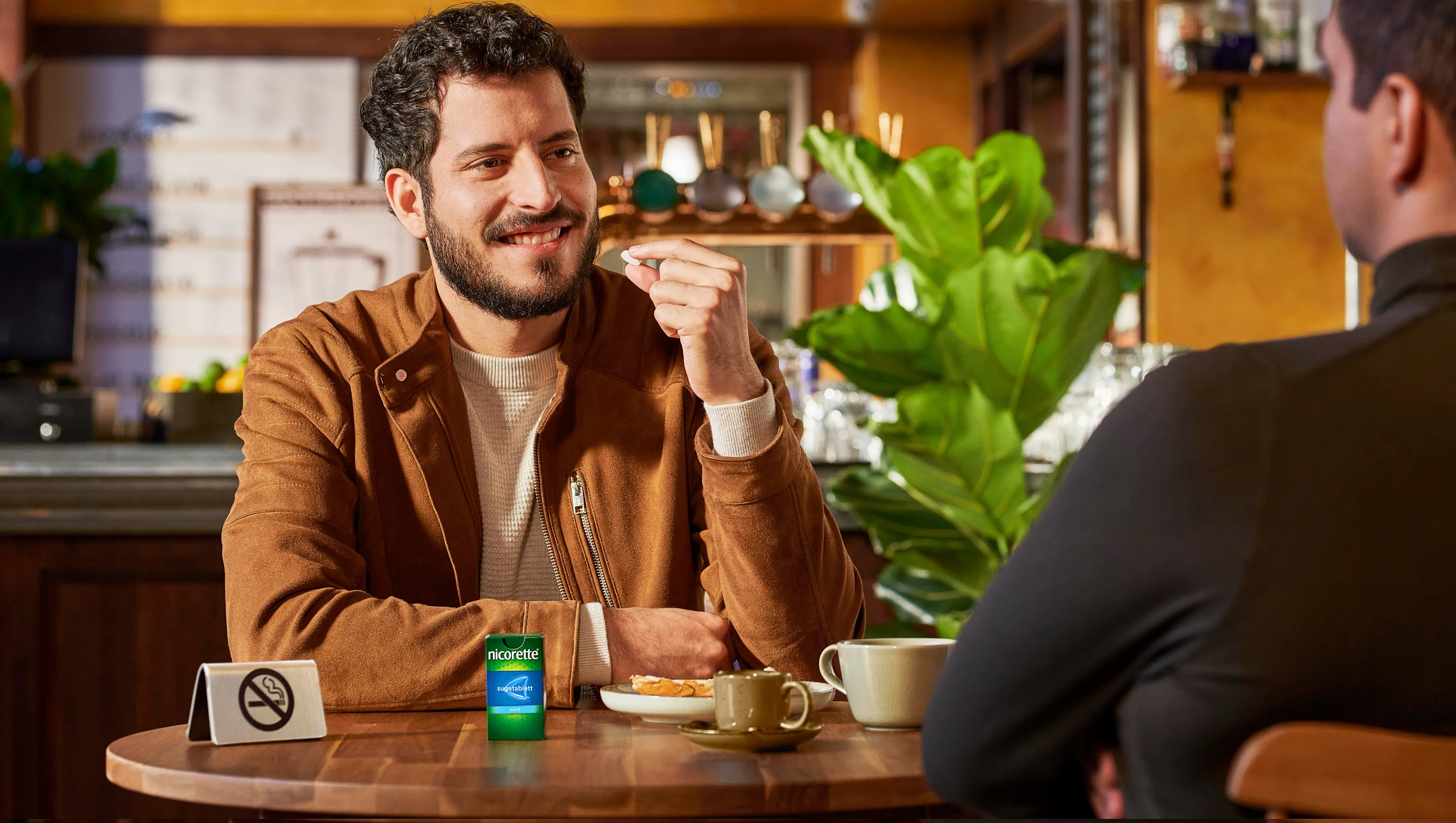 Kvinne sprayer Nicorette munnspray i munnen mens hun er på farten