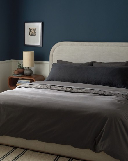 A neatly made bed with dark grey shale organic cotton sheets