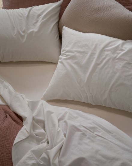 A messy bed with white cotton percale sheets