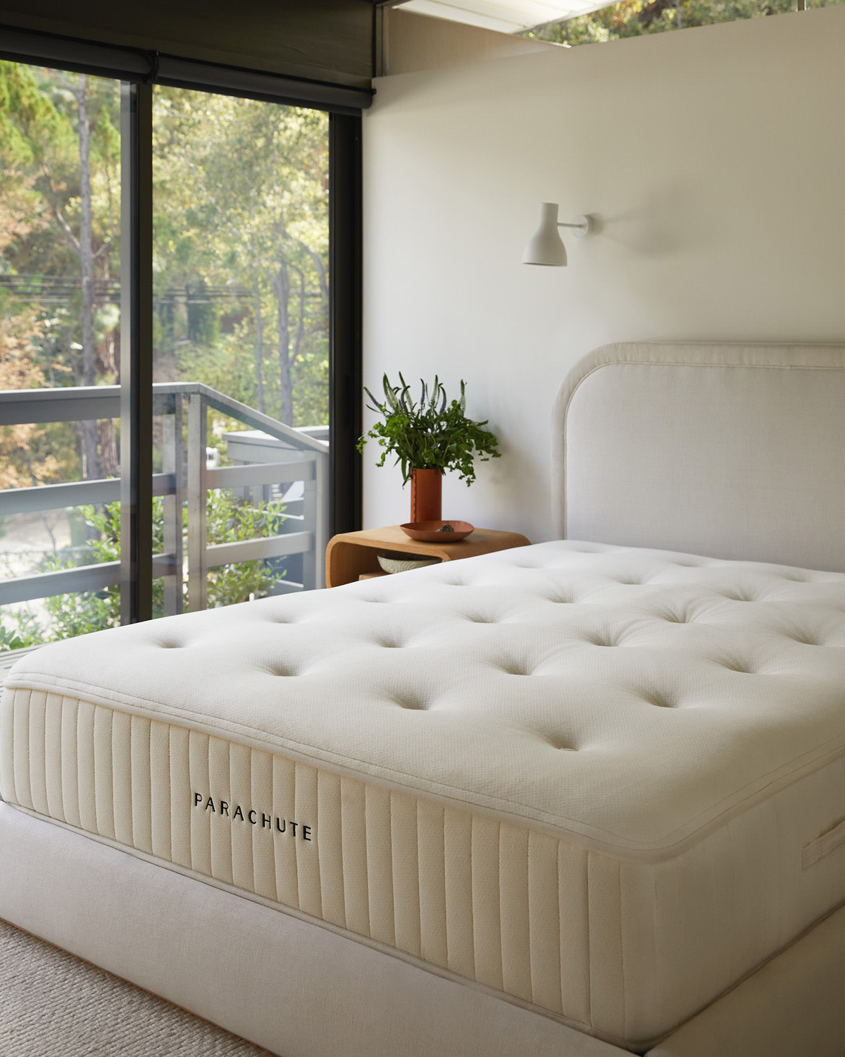 A bare Parachute mattress in a bright bedroom.