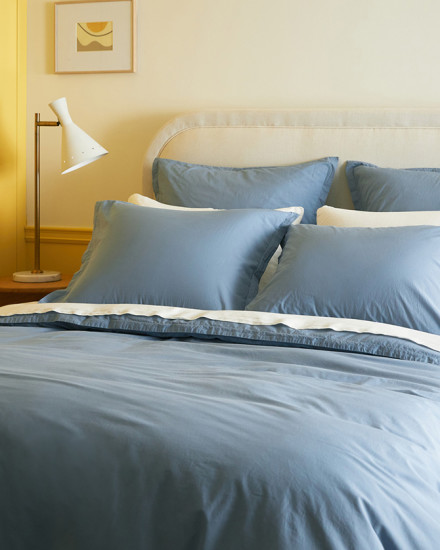 A bed with wave blue percale sheets