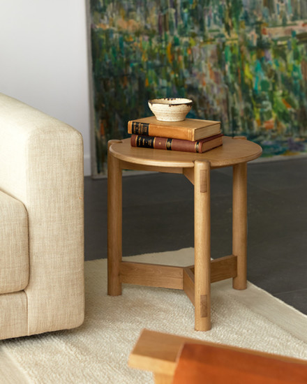 A round side table with a marble top and white oak base