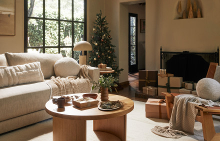 A festive living room with plush furniture and a cozy holiday tree