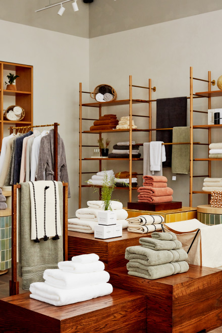 Shelves and tables with neatly stacked towels and hanging robes
