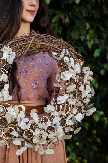 Woman holding the finished wreath.