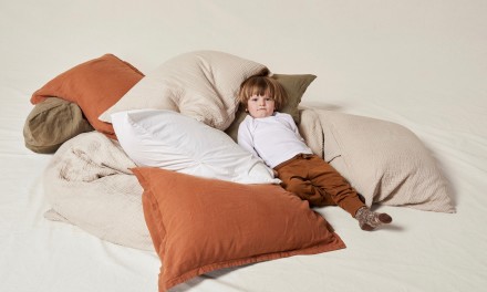 Little boy surrounded by pillows. 