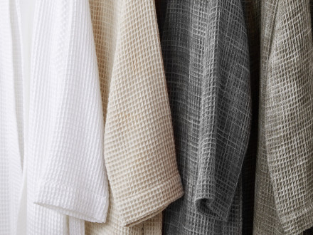 White, tan, moss, and grey waffle robes hanging side by side
