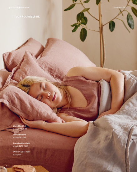 Woman laying in linen loungewear in a linen bed