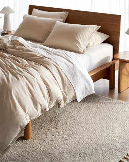 A bed with bone and white percale sheets