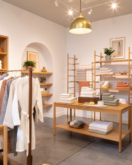 Tables and shelves filled with various towels and bathroom accessories