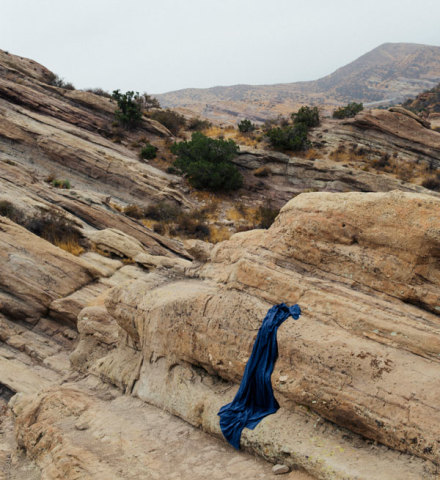 Indigo fabric drapped over a boulder in the desert.