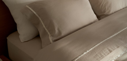 Bone and cream organic soft luxe sheets on a neatly made bed