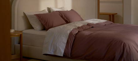 A bed with clover and white brushed cotton sheets