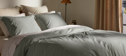 A bed with white, bone, and spa cotton percale sheets