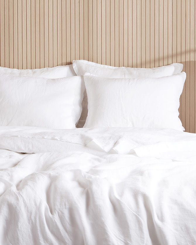 A bed with white linen sheets