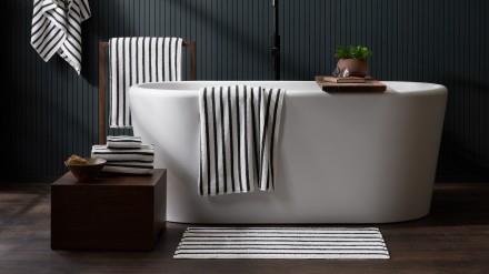 white and black resort stripe towels in a moody bathroom