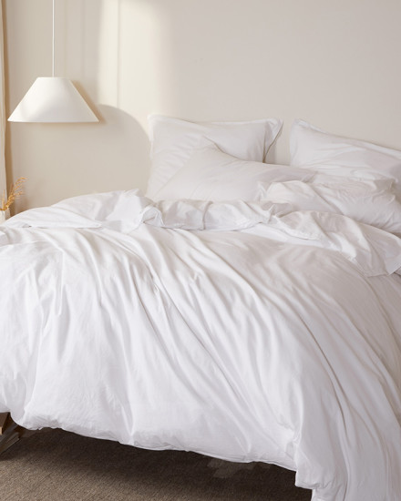 A messy bed with bright white percale sheets