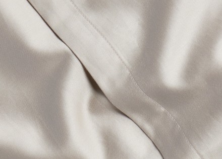 A detail photo of bone sateen sheets