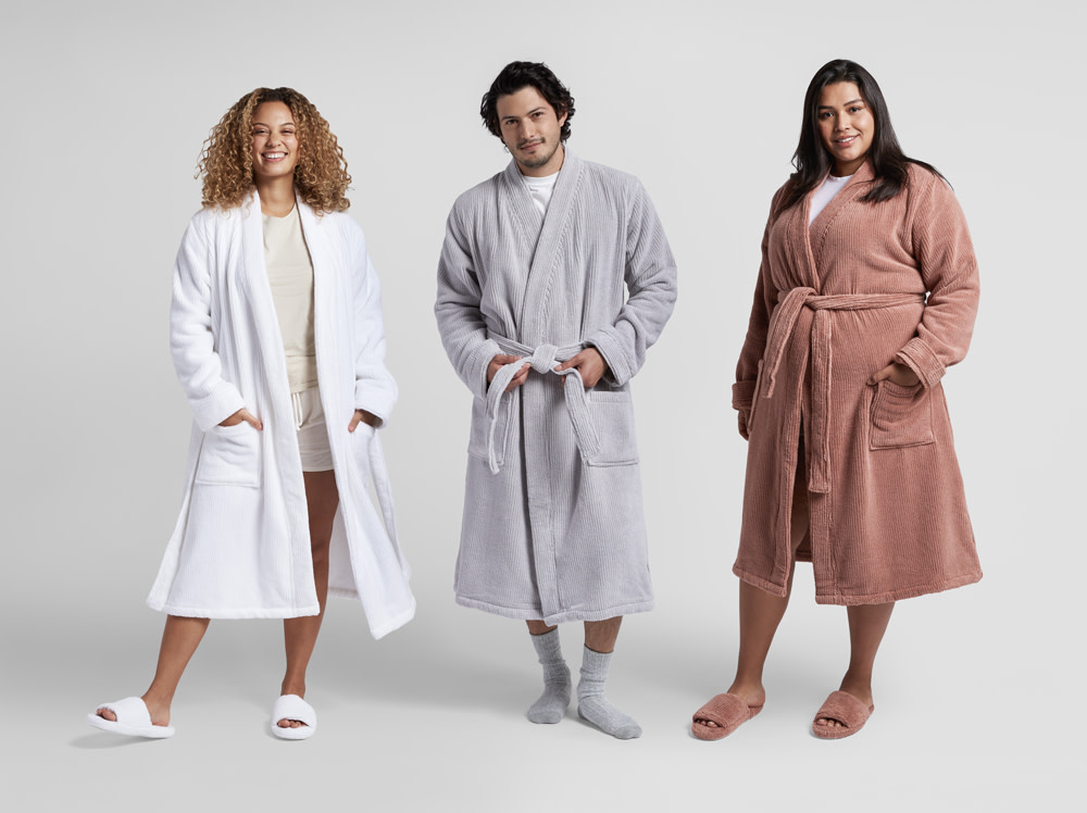 Two women and a man standing next to each other in soft rib robes.