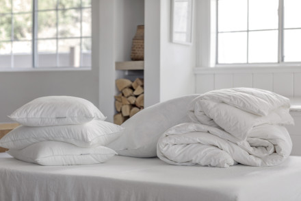 Multiple down duvets hanging inside a room.