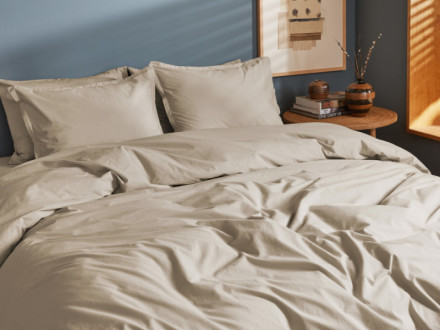 Front angle of a made bed featuring Latte bedding