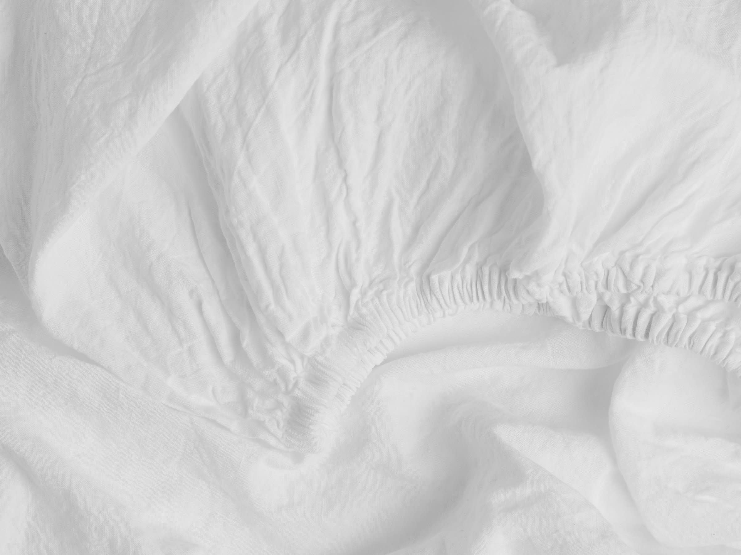 Close Up Of White Linen Crib Sheet