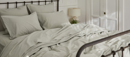 A bed with willow Organic Cotton sheets