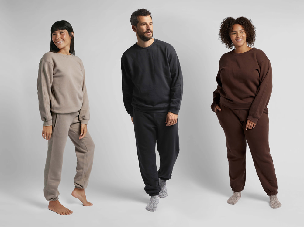 Two women and a man modeling loungewear on a white backdrop
