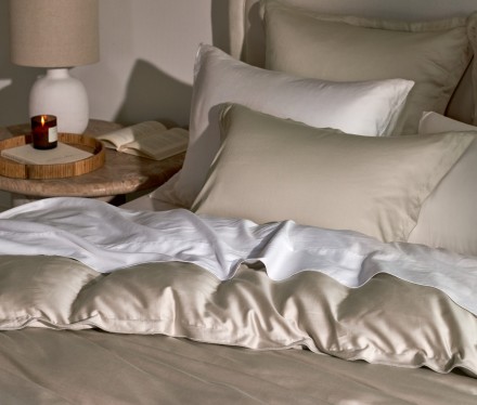 A chic bed with white and bone sateen sheets