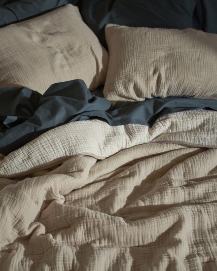 A cozy bed with dusk brushed cotton sheets and a natural and ivory cloud cotton quilt