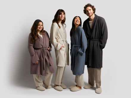 Three women and a man standing next to each other in cloud cotton robes.