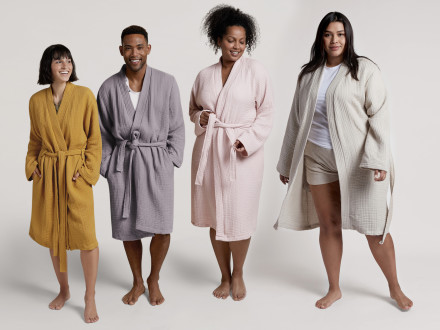 Three women and a man standing next to each other in cloud cotton robes.