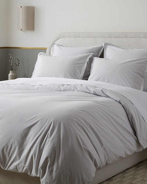 A neat bed with white and light grey mist brushed cotton sheets