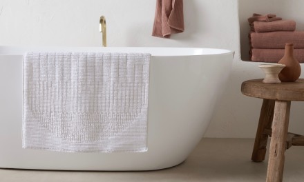 Bath rug with clay towels along bathtub. 