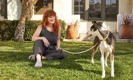 Women sitting in grass with her dog