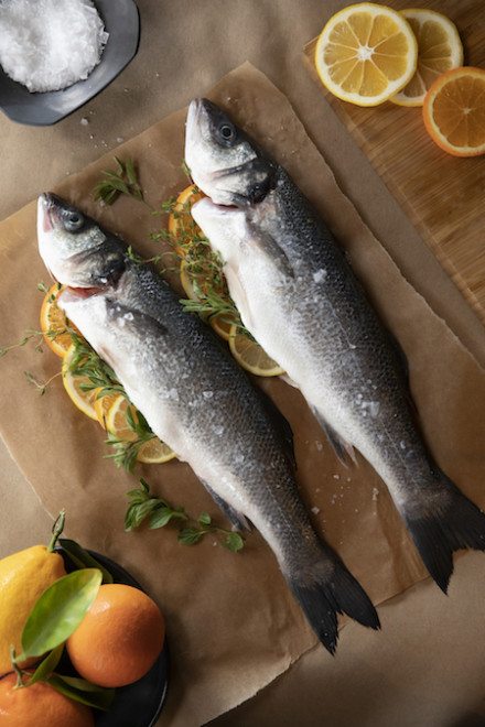 Branzino with citrus being prepared. 