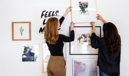 Two women hanging a photo