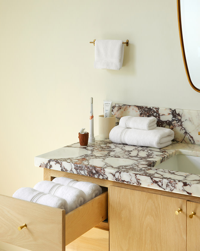 White towels stacked neatly on a marble bathroom counter